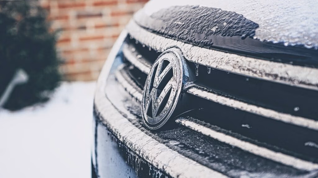 Front of a Volkswagen vehicle affected by cold weather, parked with frost