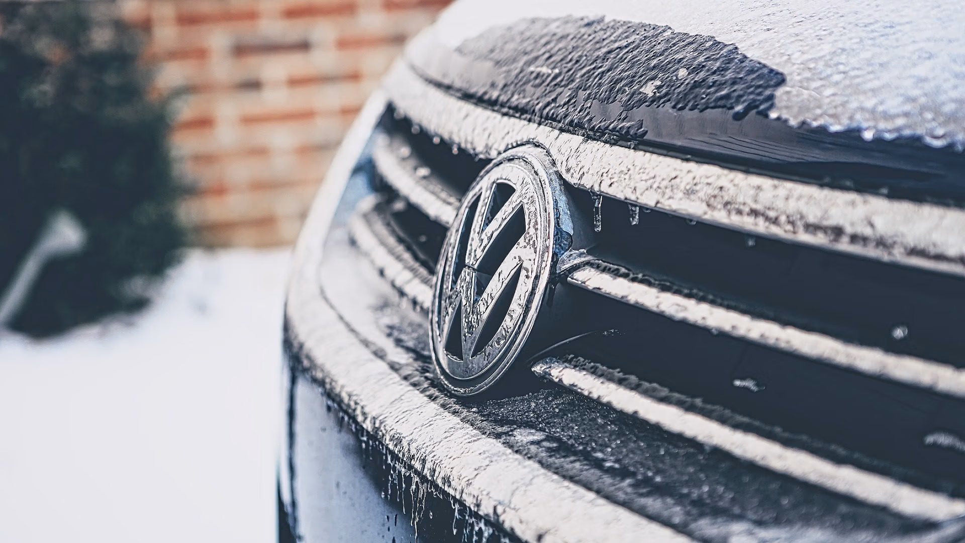 Front of a Volkswagen vehicle affected by cold weather, parked with frost