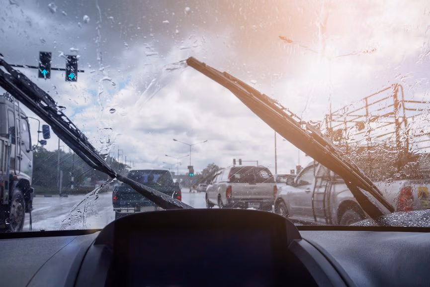 Car windshield wipers on a rainy day, emphasizing visibility and safety