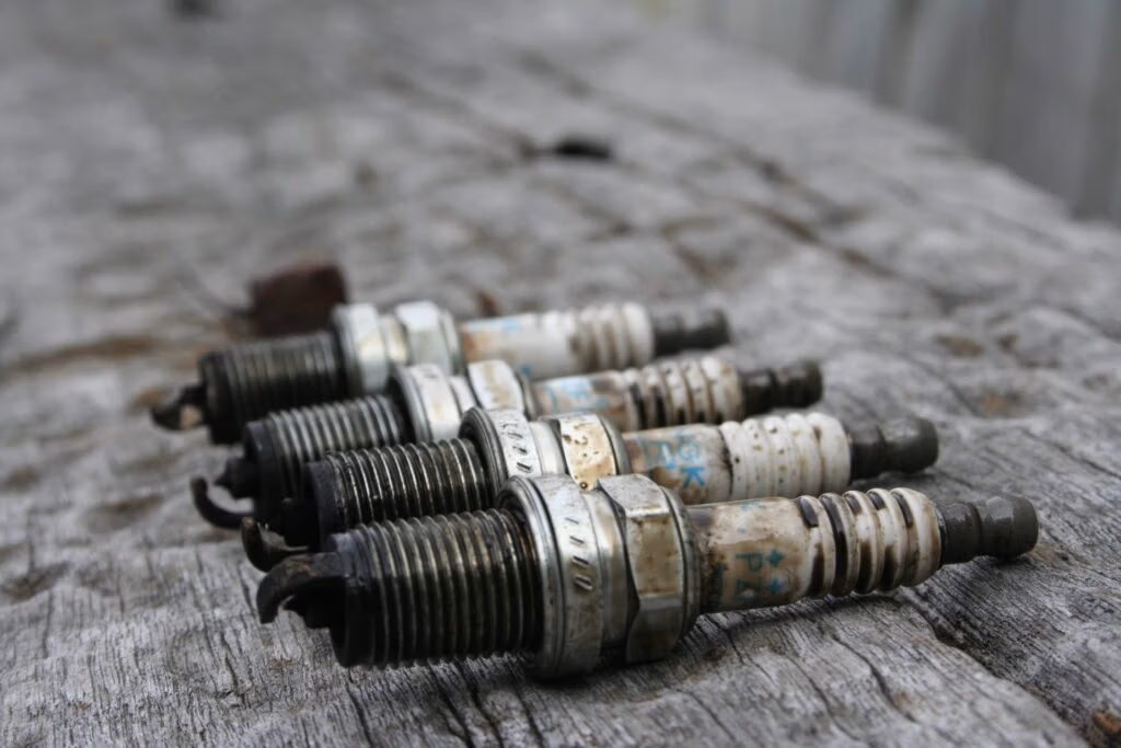 Mechanic inspecting spark plug during vehicle service in Hamilton