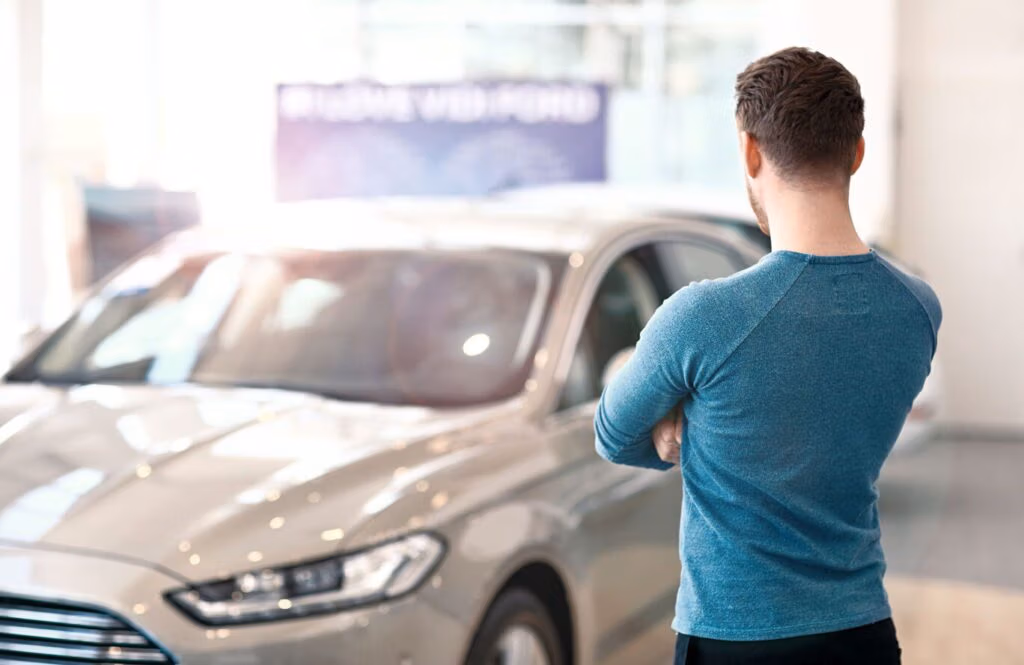 Tânăr evaluând o mașină folosită la CRS Automotive în Cambridge, ON