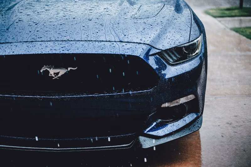 Driving a car in heavy rain on a wet road, headlights on